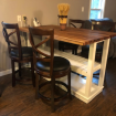 white kitchen island with wood top and chairs